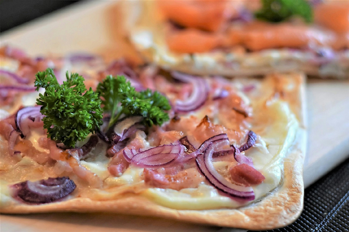 La tarte flambée alsaziana: pasta croccante e ripieno abbondante per i pranzi di tutti i giorni